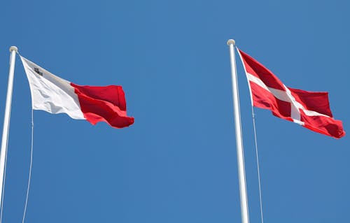 Rote Und Weiße Flagge Am Pol Unter Blauem Himmel