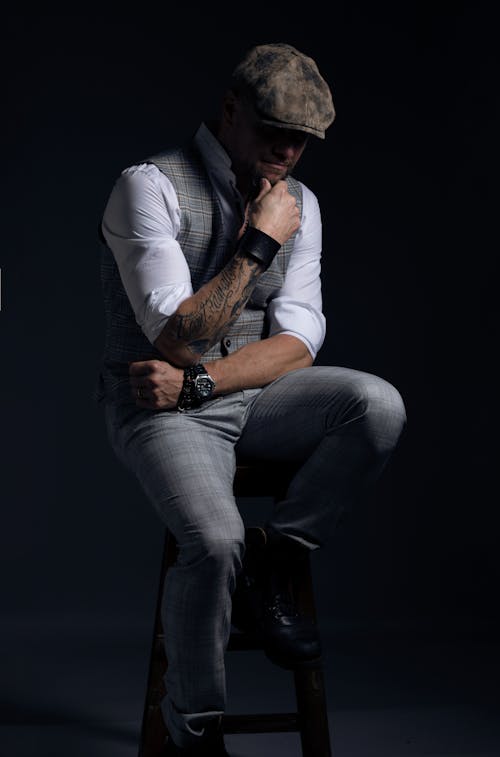 Man in Long Sleeves and Gray Pants Sitting on a Stool