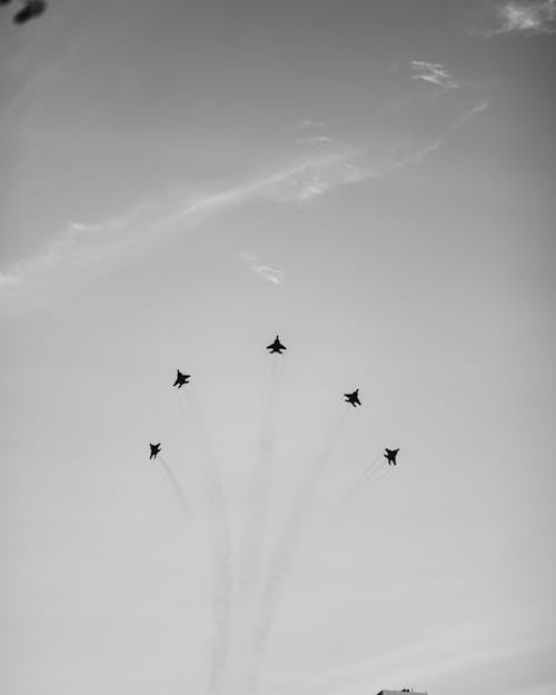 Free From below black and white powerful fighter airplanes performing tricks in sky during air show Stock Photo