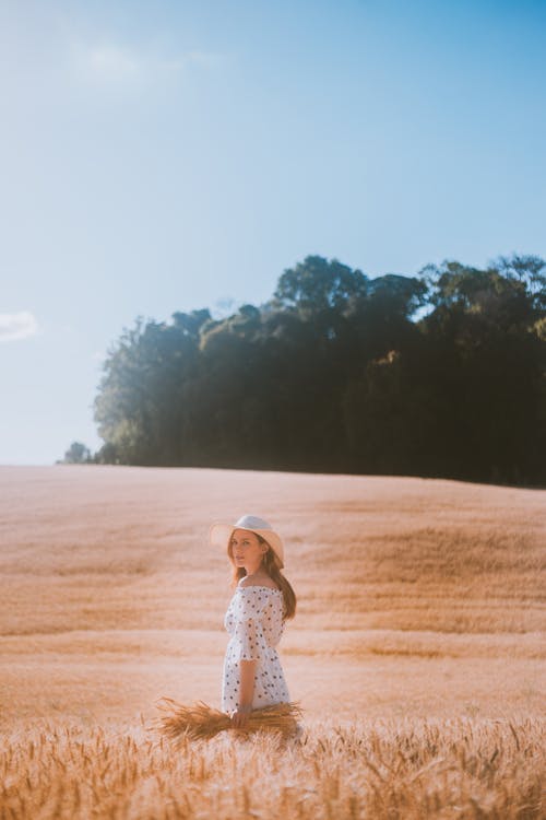 Free Woman Standing on Wheat Field Looking Back Stock Photo