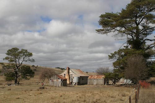 Wooden Barn on a Field Under Blue Sky