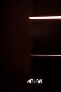 在黑暗的背景中，喜怒无常的霓虹灯照片与文字“与爱”相映
