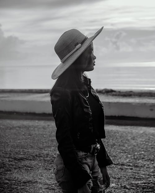 Free Woman Wearing a Leather Jacket and Hat Looking Afar Stock Photo