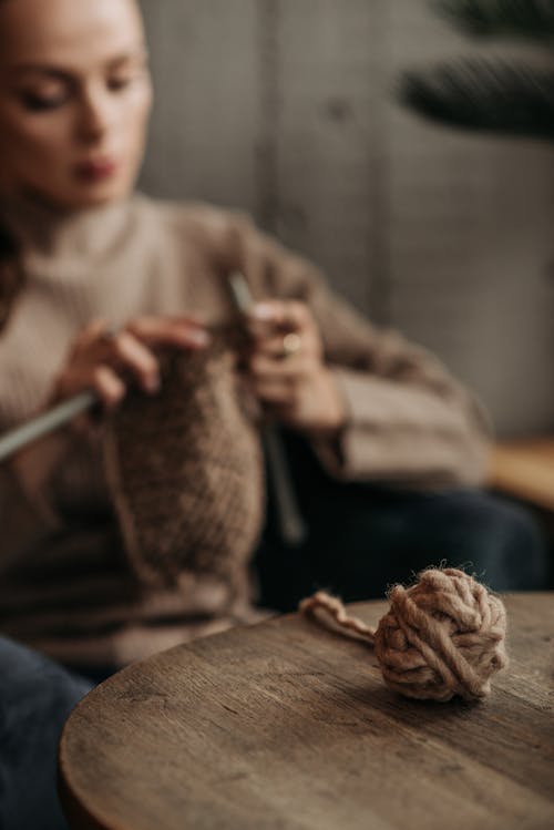 Free Woman in Brown Long Sleeves Knitting a Brown Yarn Stock Photo