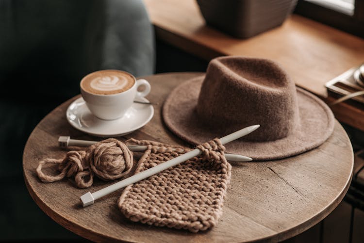 Crochet  And Hat On Top Of A Round Table