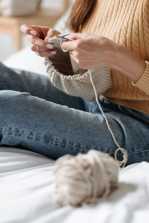Free Woman knitting with beige yarn in cozy indoor setting, focused on hands in action. Stock Photo
