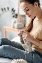 Woman in Beige Knit Sweater Holding White Rope