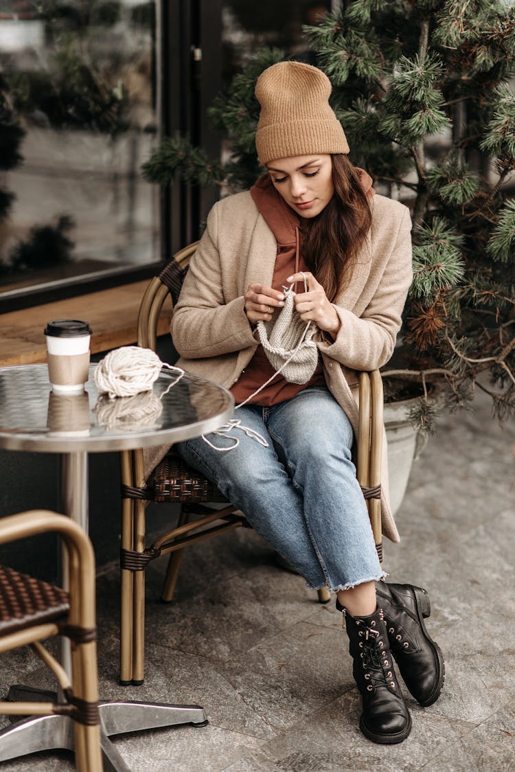 A Woman Sitting While Knitting