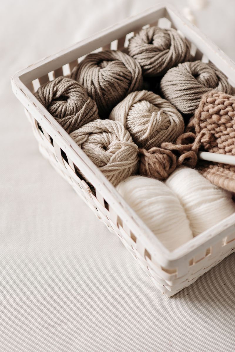 Colorful yarn skeins organized neatly on shelves in a small craft storage setup