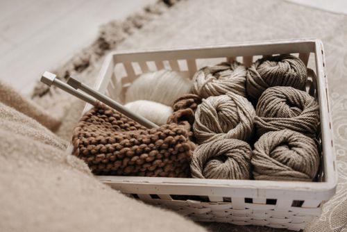 Free A basket filled with wool yarn and knitting needles, perfect for craft enthusiasts. Stock Photo