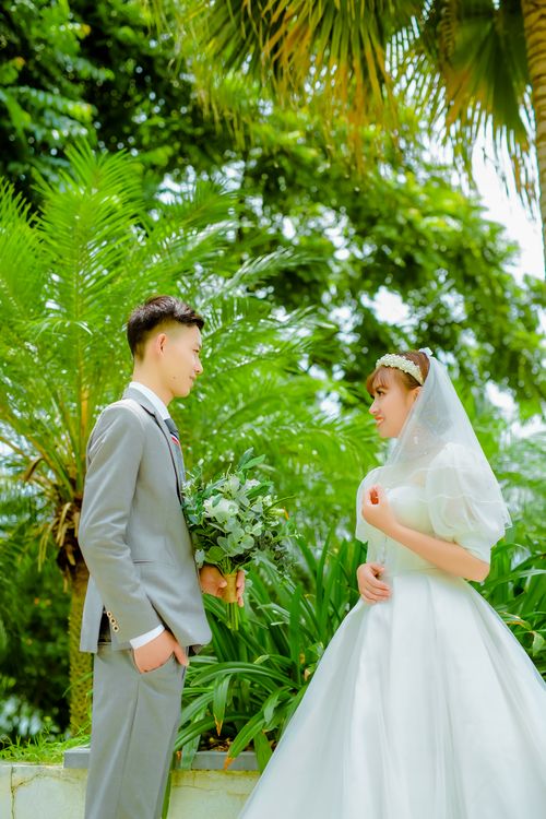 Free Bride and groom in lush garden setting, capturing love and romance. Stock Photo