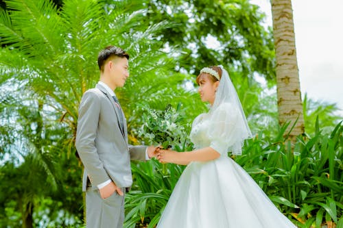 Photo of a Bride and a Groom Looking at Each Other
