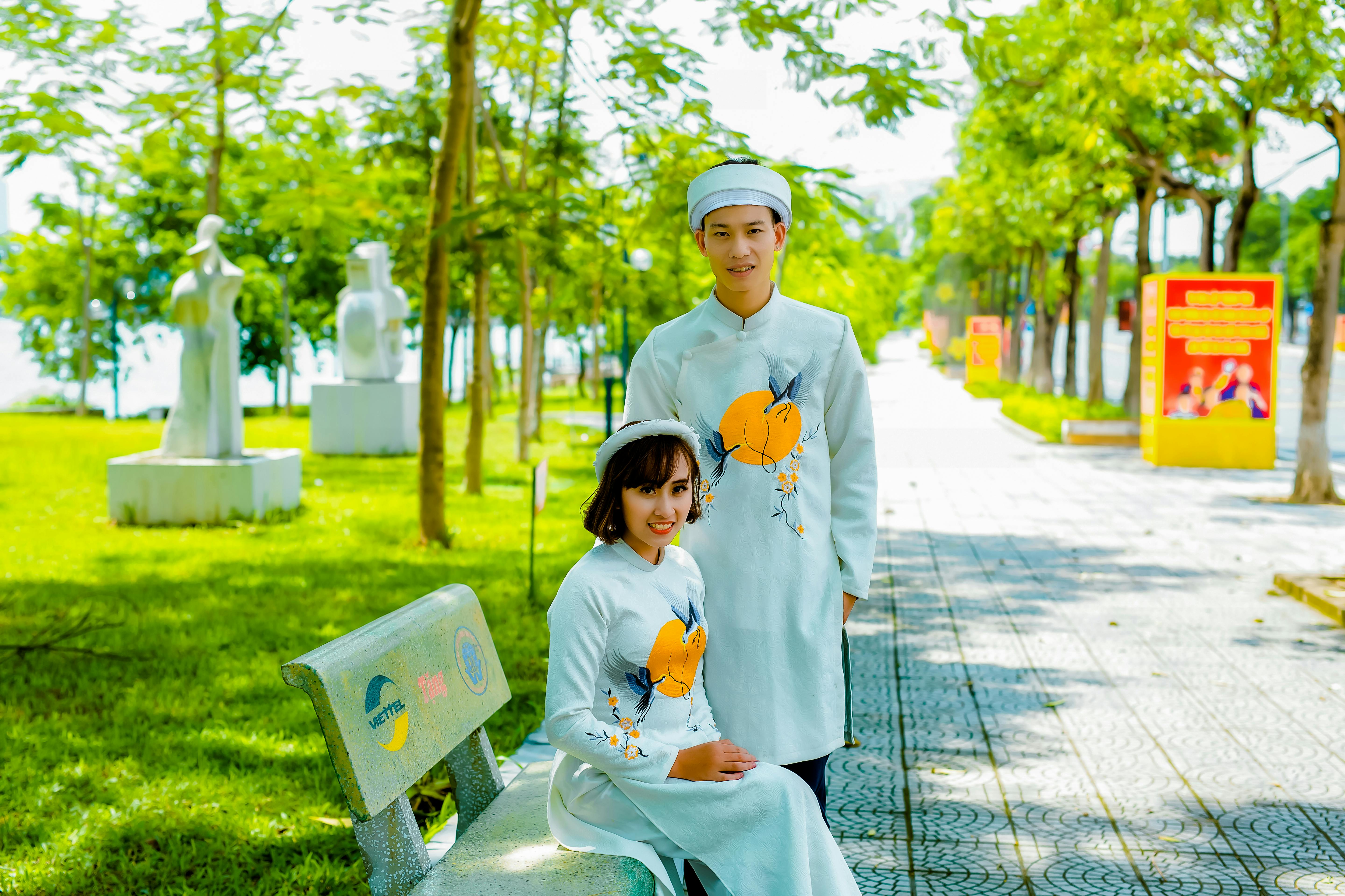 photograph of a couple in white traditional clothes looking at the camera