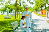 Photograph of a Couple in White Traditional Clothes Looking at the Camera