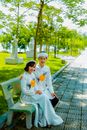 Photograph of a Couple in Traditional Clothes Sitting on  a Bench