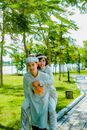 Photo of a Man in Traditional Clothes Carrying a Woman while Smiling