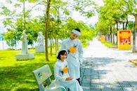 Photo of a Woman in a White Dress Sitting Beside a Man