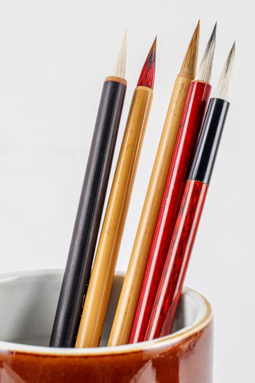 Assorted colorful Japanese calligraphy brush pens with spiky tips and bamboo shafts on white background