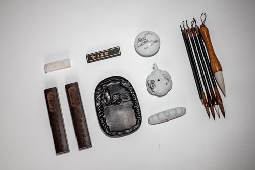 Free Flat lay of traditional Chinese calligraphy tools including ink stone, brushes, and ink sticks. Stock Photo