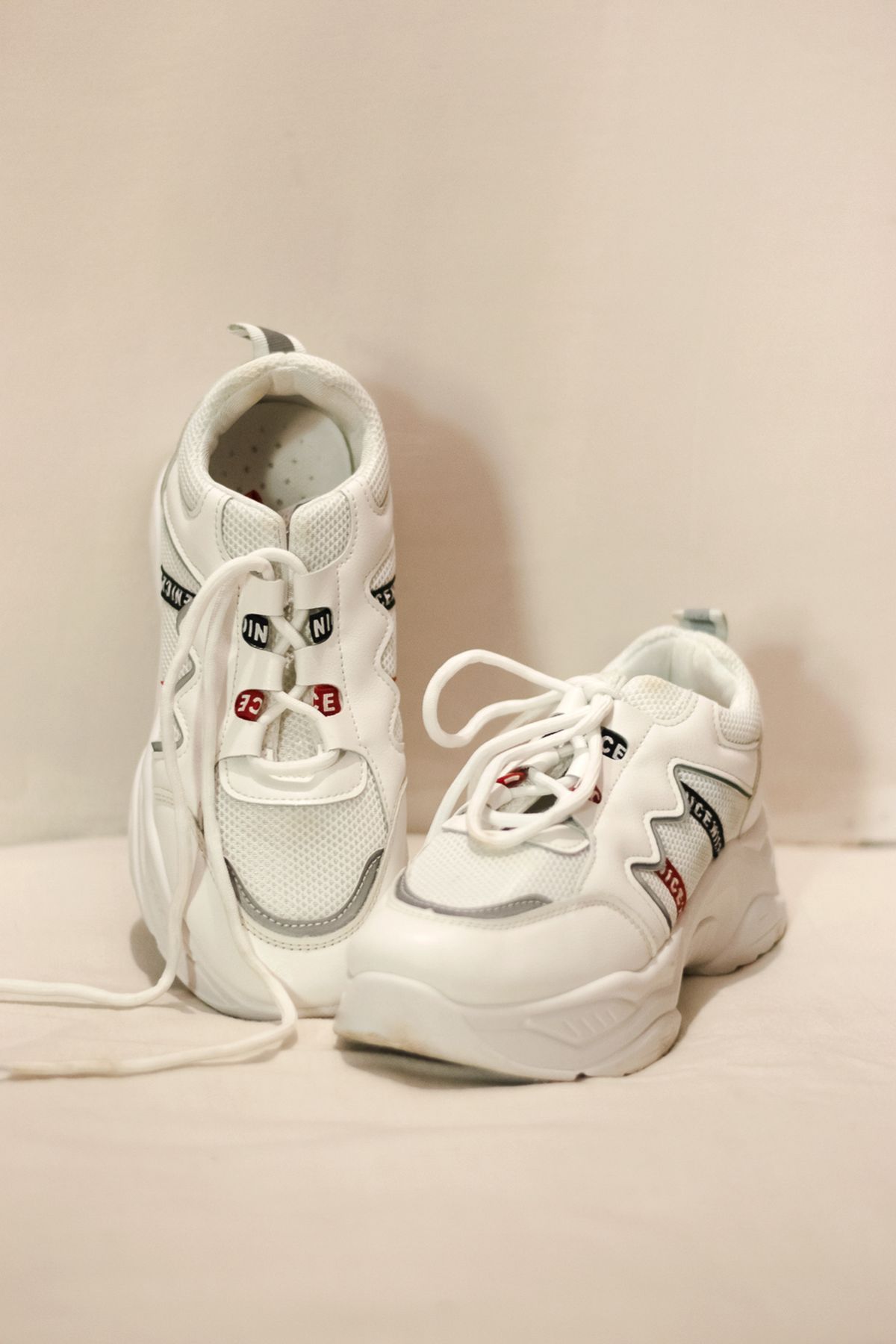 Sepasang sneakers chunky putih dengan sole tebal cocok untuk gaya denim oversized streetwear