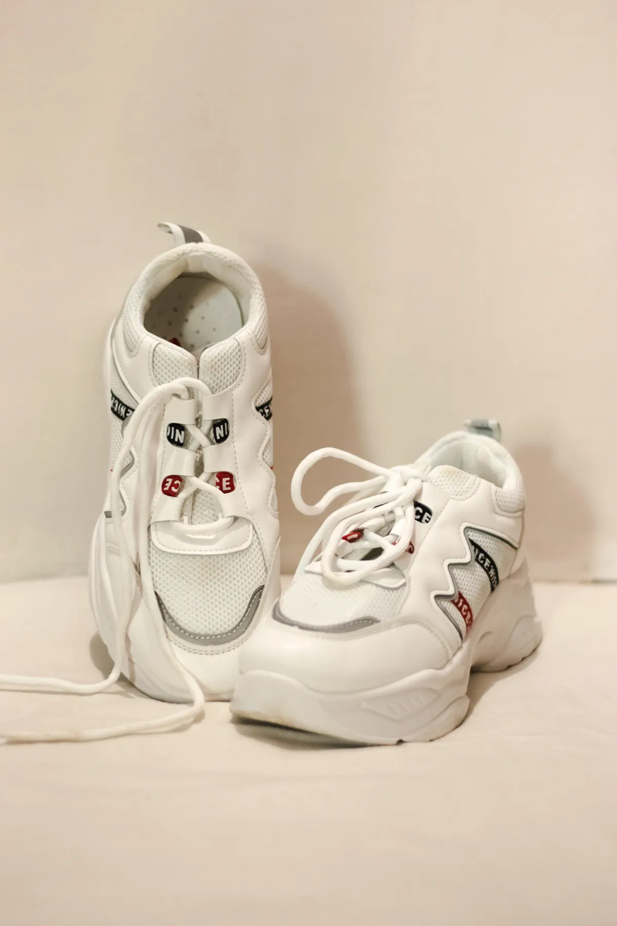 Sepasang sneakers chunky putih dengan sole tebal cocok untuk gaya denim oversized streetwear