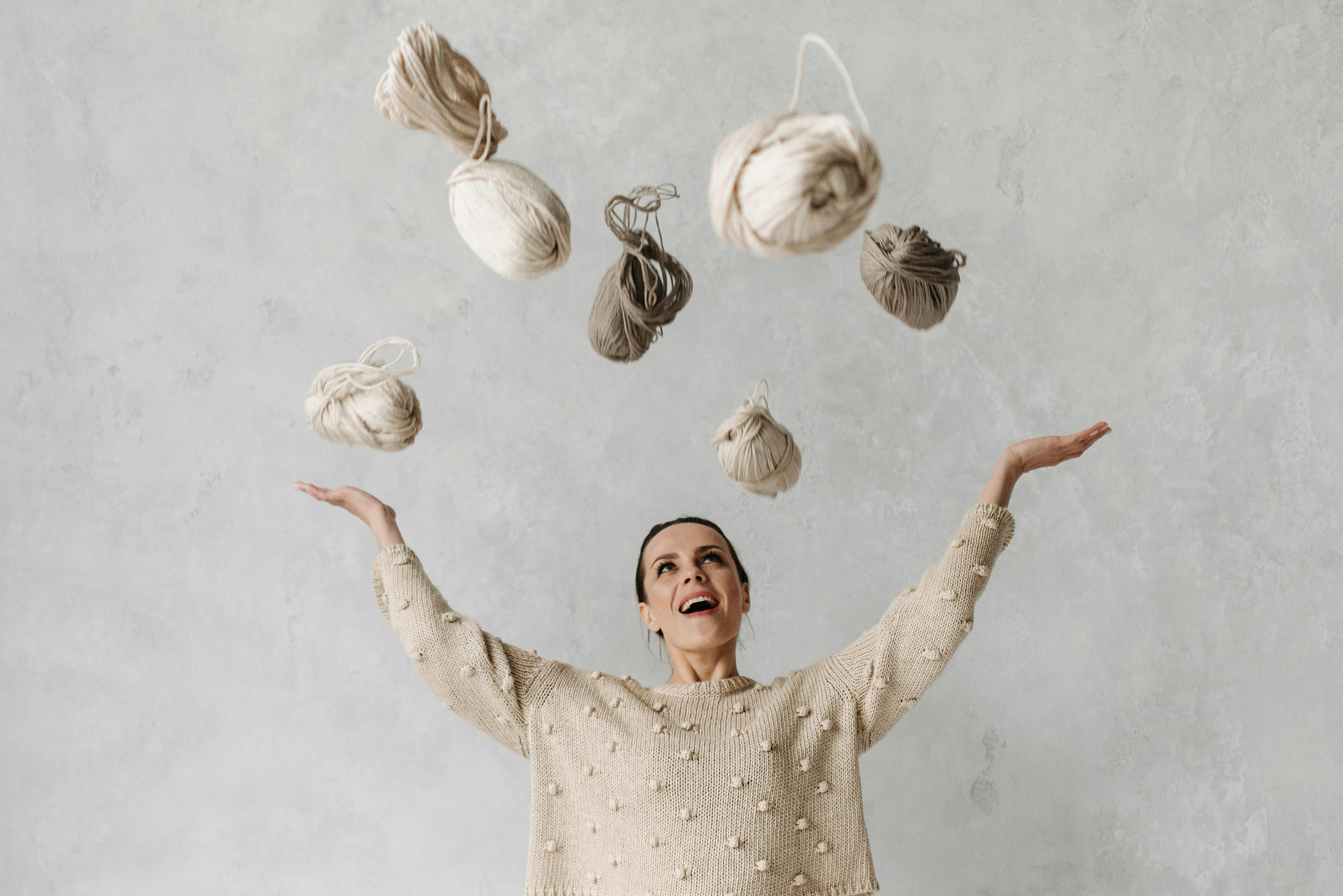 A Woman in a Sweater Throwing Yarns · Free Stock Photo