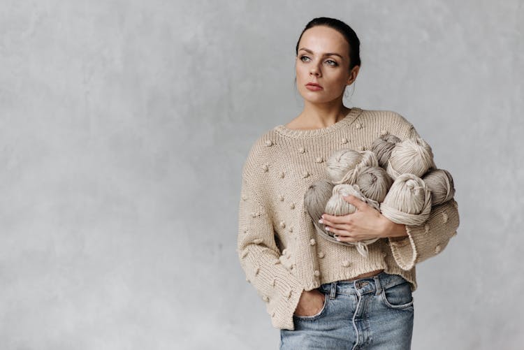 Woman In A Sweater Holding Yarns