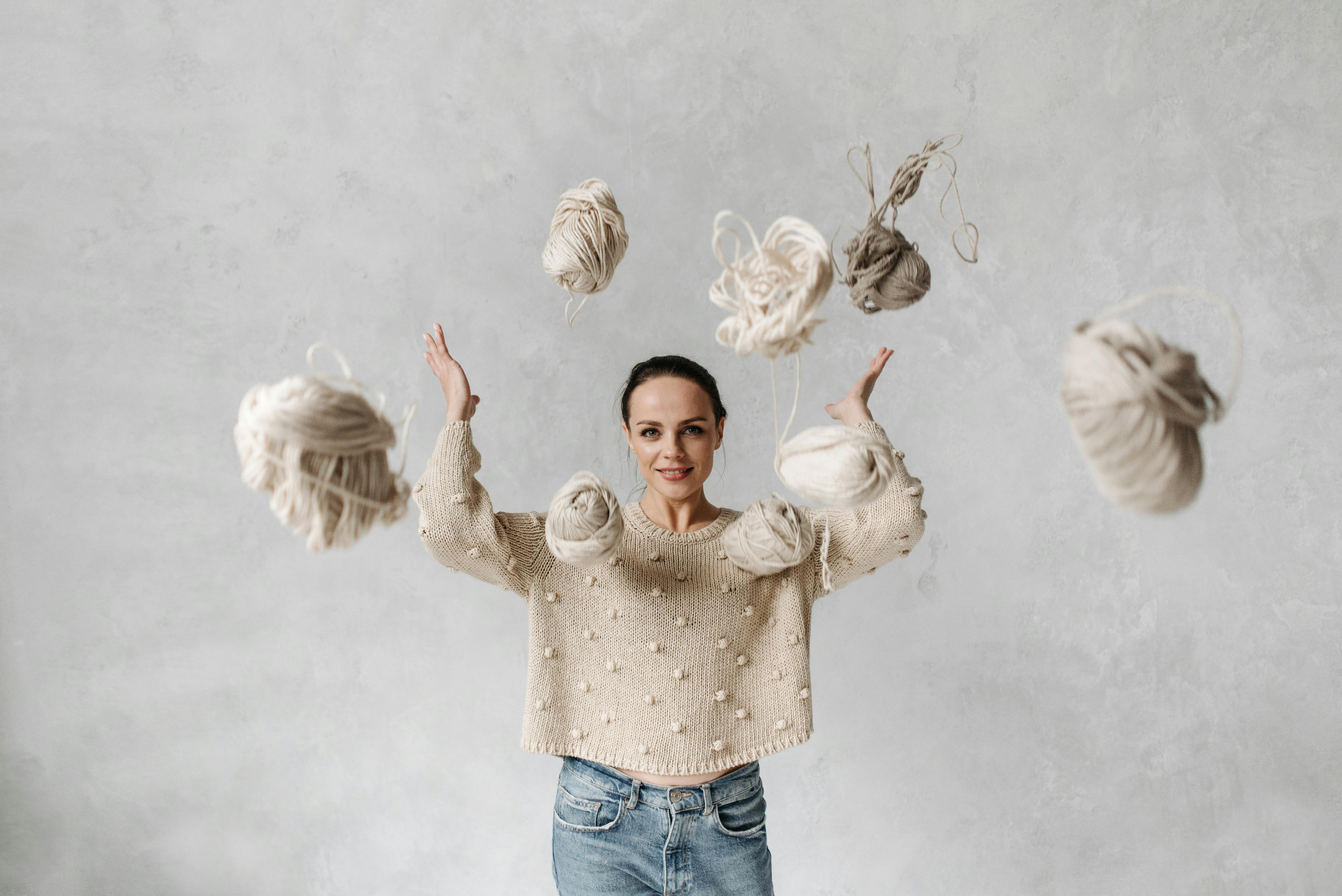 Girl in White Sweater Throwing Yarn Balls · Free Stock Photo