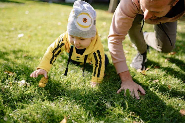 A Kid Crawling On The Grass