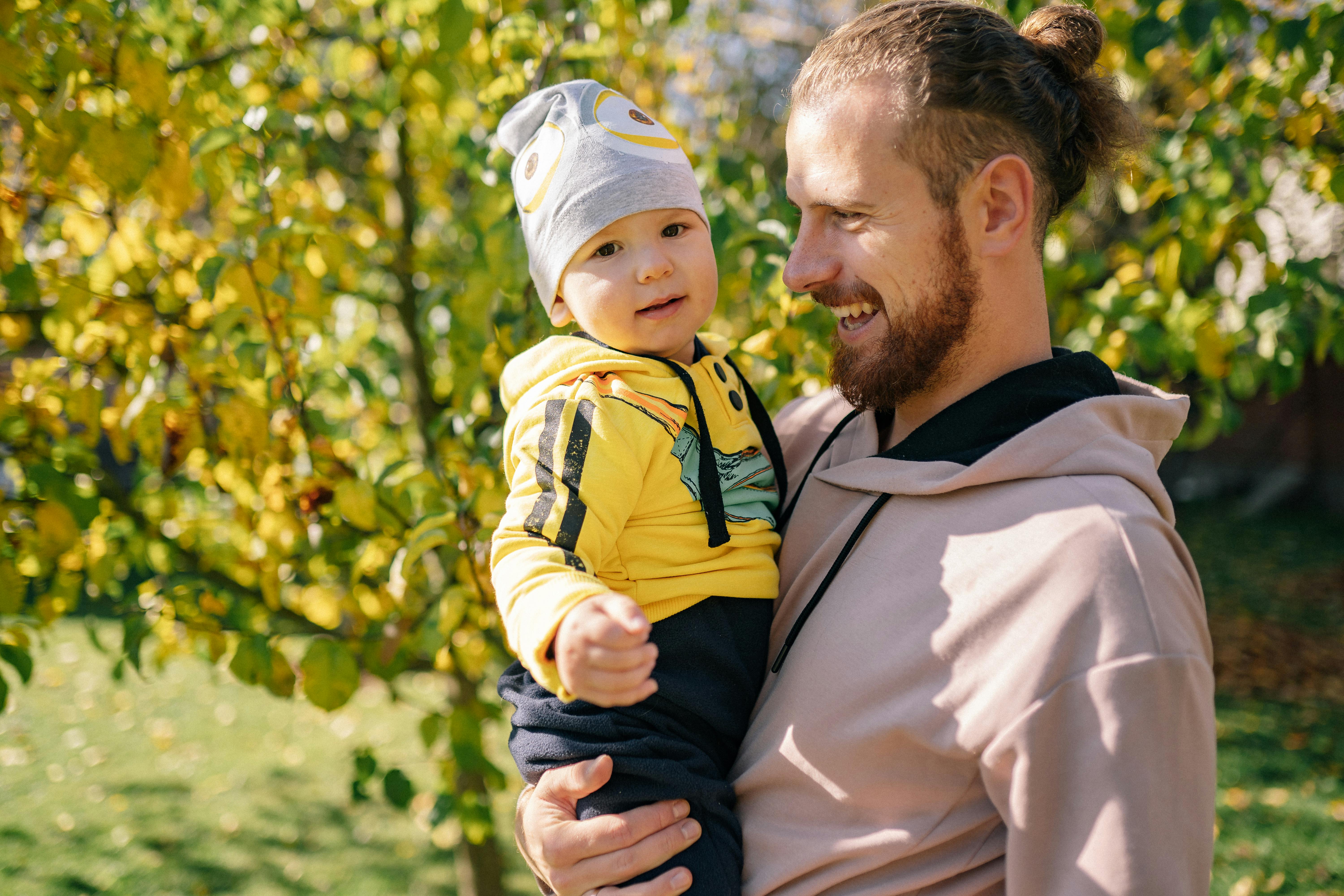 Man Carrying Baby Outside · Free Stock Photo