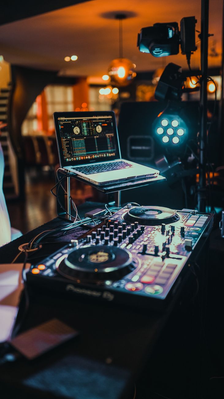 Een levendige binnen DJ-booth met een laptop en muziekcontroller die klaar zijn voor gebruik.
