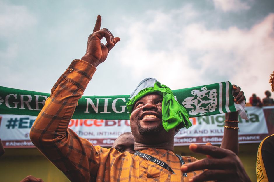 Joyous man celebrating a football victory with fans in a stadium, showing happiness and excitement.