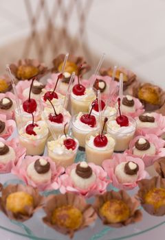 An assortment of mini desserts with cherries and chocolate, beautifully presented on a cake stand, perfect for events.