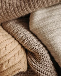 A detailed close-up of assorted knitted textiles showcasing different patterns and textures.
