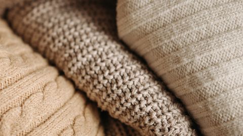 A detailed close-up of assorted knitted textiles showcasing different patterns and textures.