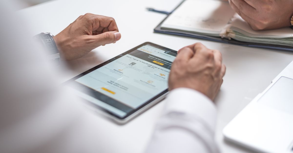 Close-up of professionals using a digital tablet and smartphone during a meeting.