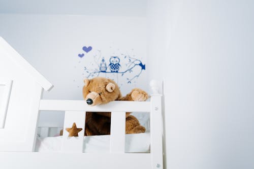 Free Brown Bear Plush Toy on a Bed Stock Photo