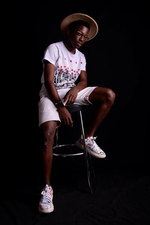 Man in White Crew Neck T-shirt and Shorts Sitting on Stainless Steel Bar Stool