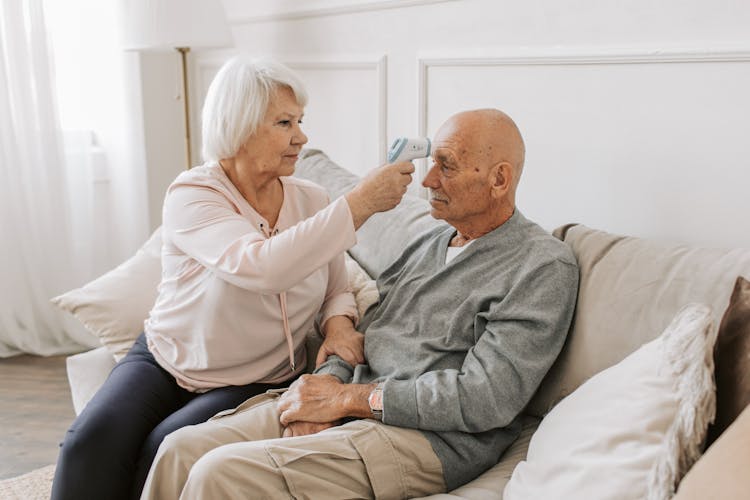 Woman Checking The Temperature Of A Man