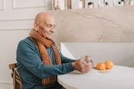Man in Blue Sweater Holding Clear Glass Mug