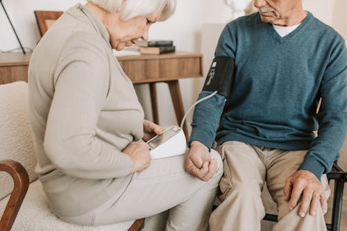 Free Elderly Woman Checking the Blood Pressure of an Elderly Man Stock Photo