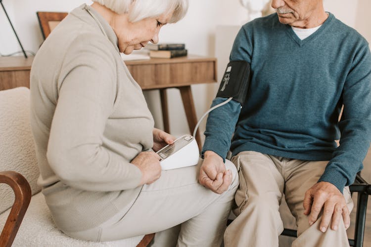 Elderly Woman Checking The Blood Pressure Of An Elderly Man