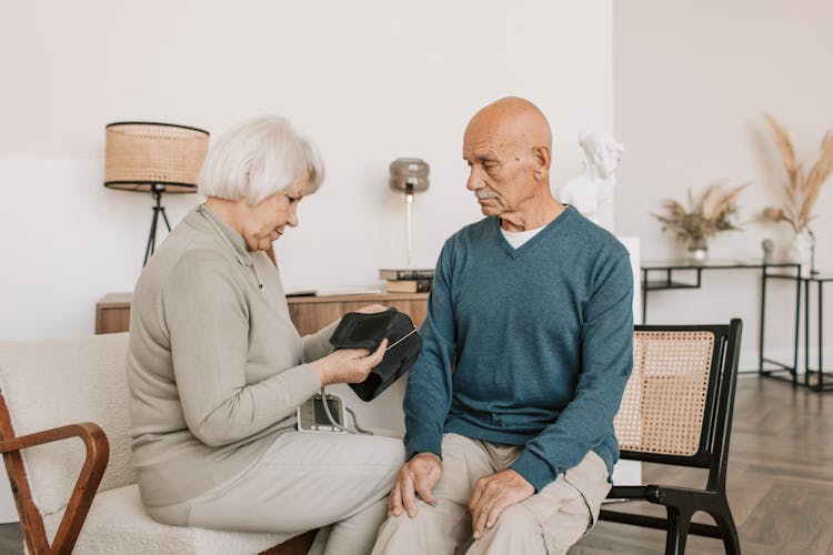 Elderly Woman Checking The Blood Pressure Of An Elderly Man