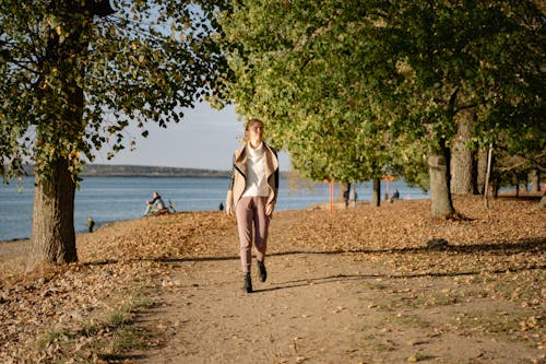 Woman Walking on a Path Along a Lake 