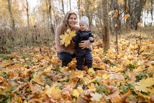 Mother and Child Sitting on Dried Leaves