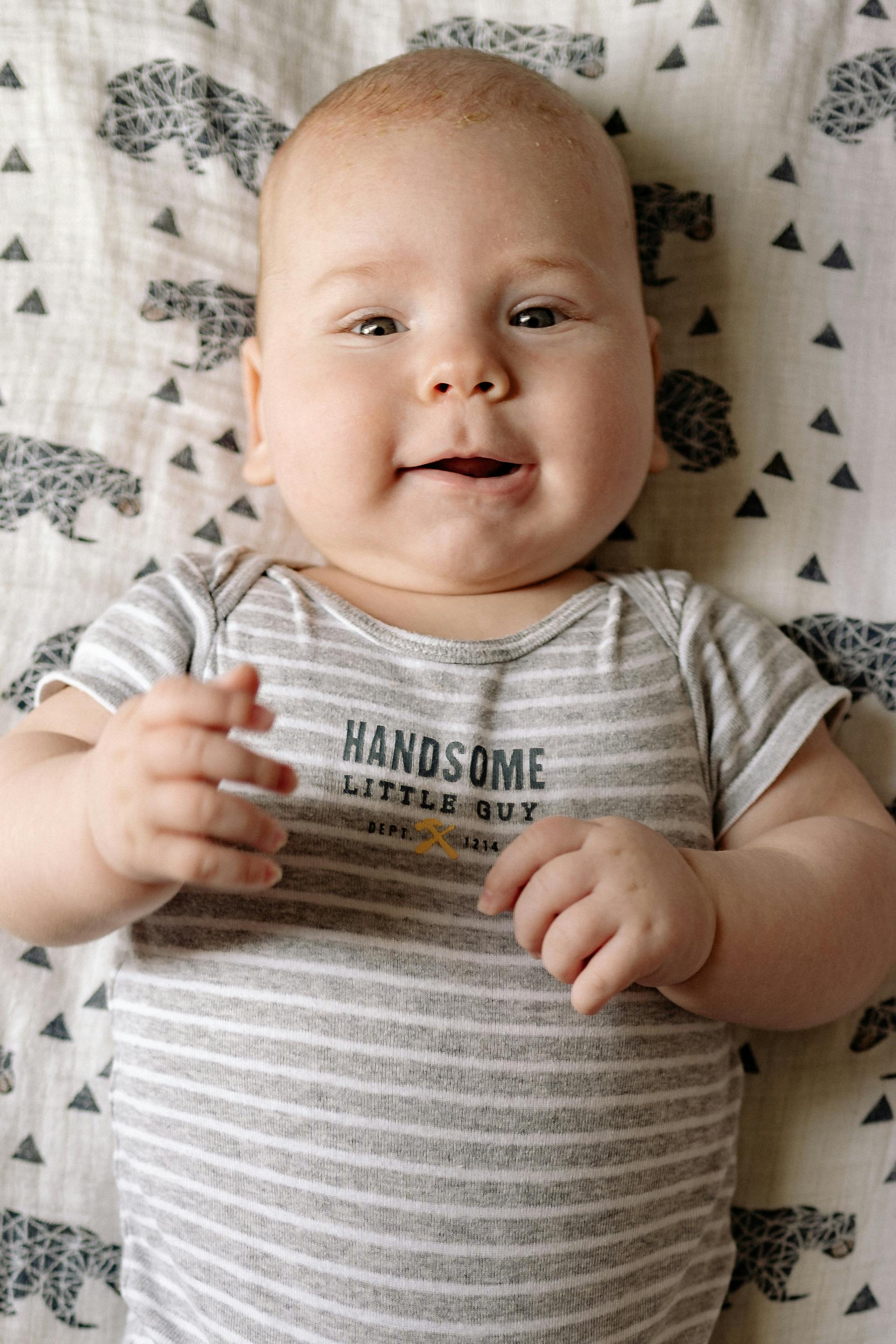 baby in white and gray stripe onesie