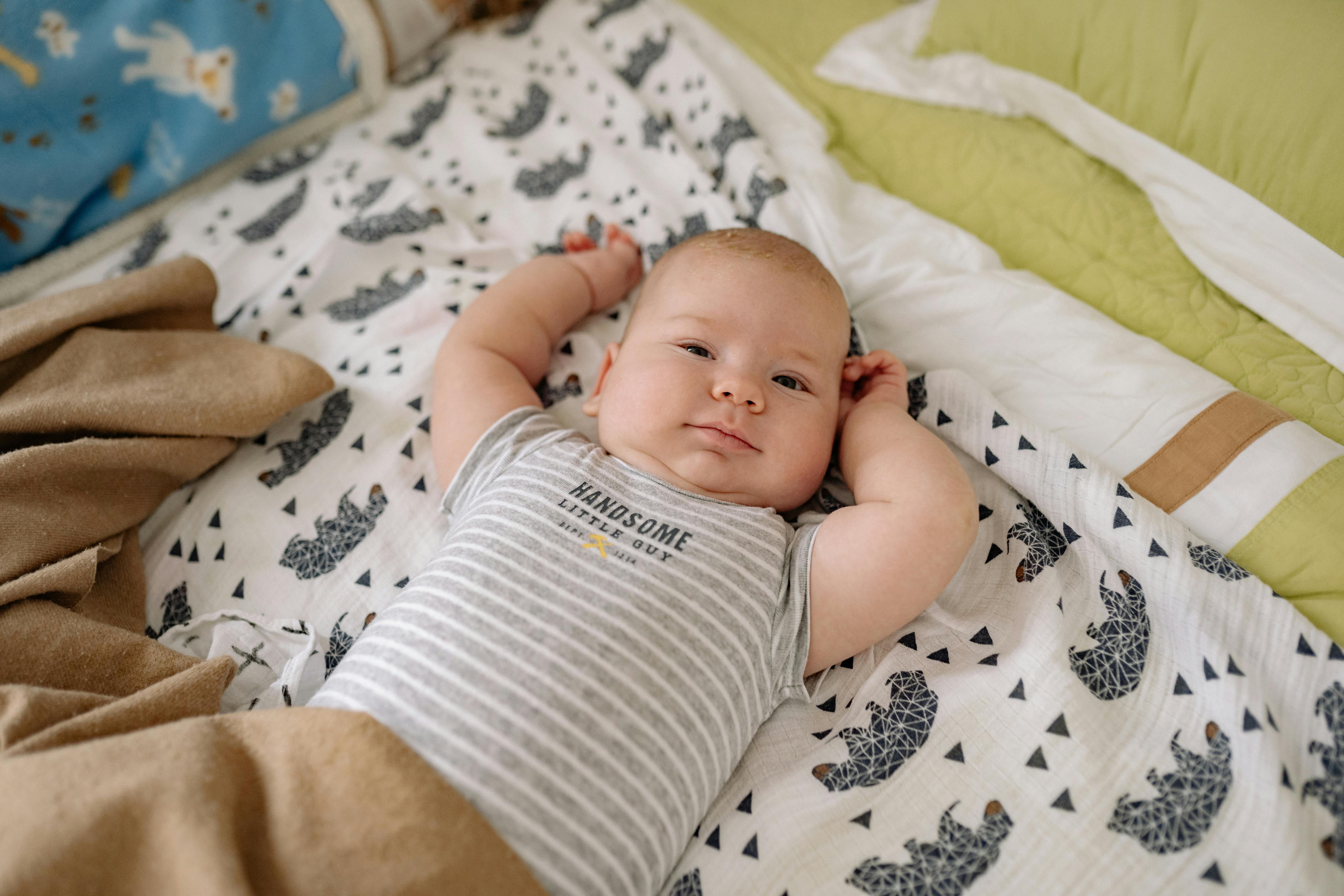 baby in white and gray stripe onesie