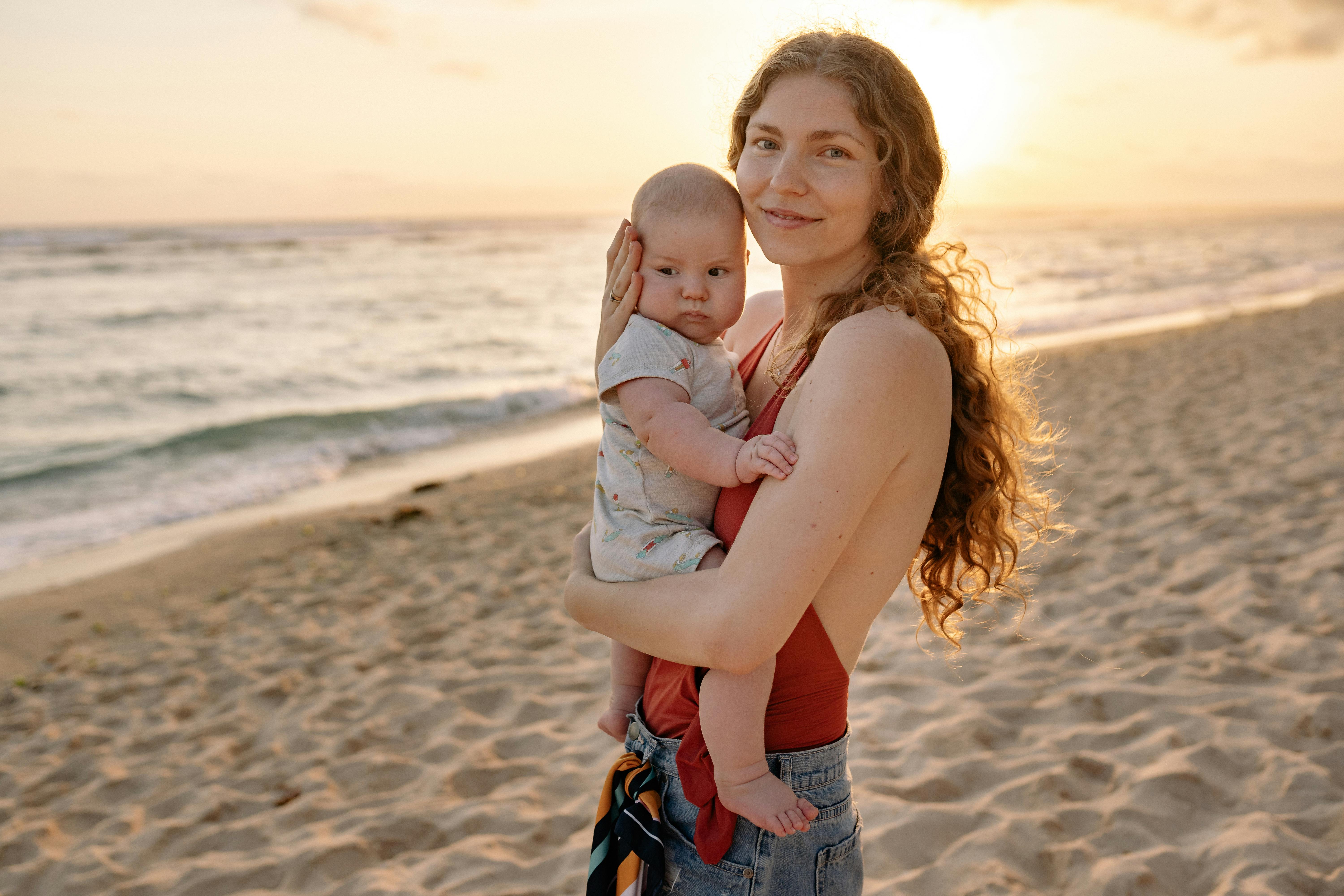 日落时分，母亲和婴儿在海滩上