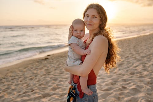 Free Mother Carrying Her Baby on the Beach  Stock Photo