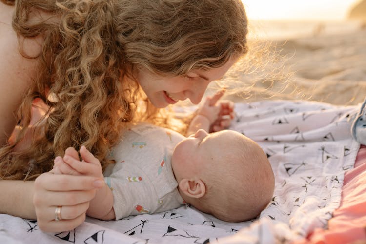 Woman Looking At Baby In Gray Onesie 